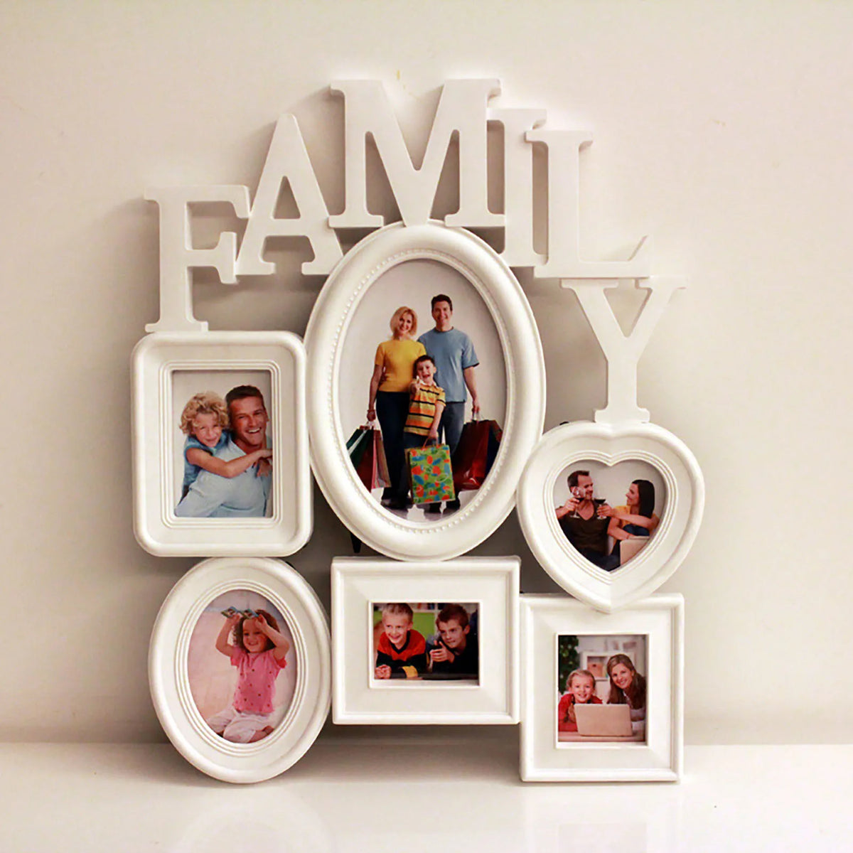 Lettres en bois blanc formant FAMILY avec des photos encadrées disposées en forme de cœur