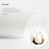 A close-up view of a white canvas fabric texture with a piece of natural brown material resting on it.