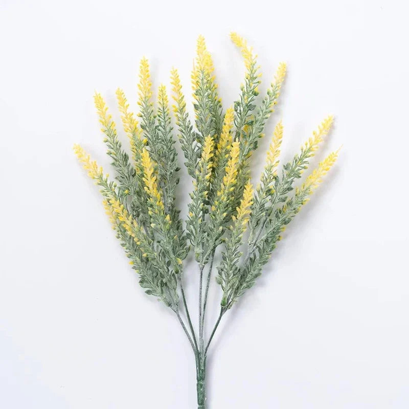 Sprigs of artificial yellow lavender flowers with green foliage.