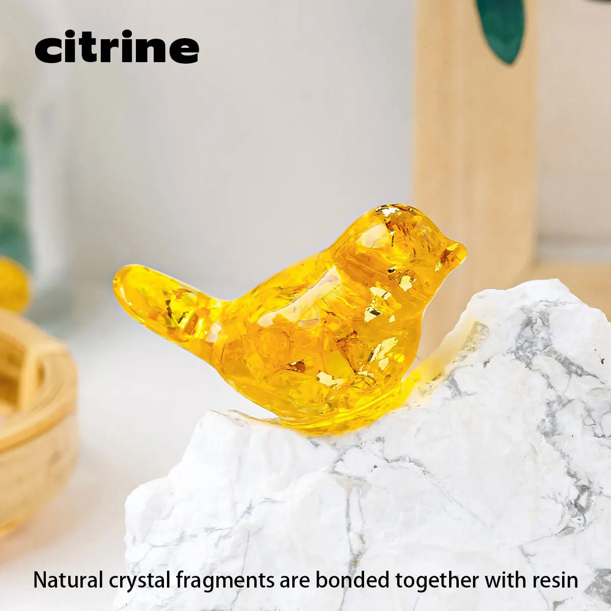 A bright yellow crystal bird statue made of natural crystal fragments is placed on a white marble surface.