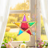 A forged iron star hanging candlestick with multicolored glass facets, suspended in a bright window setting.