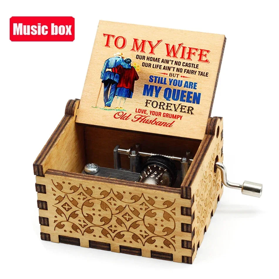 An antique wooden hand crank music box with an engraved lid featuring a poem to his wife