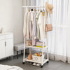 A white adjustable metal coat rack with wooden hangers and a straw hat hanging on it.