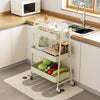 A white 3-tier metal rolling storage cart filled with various kitchen items like jars and produce on a countertop.