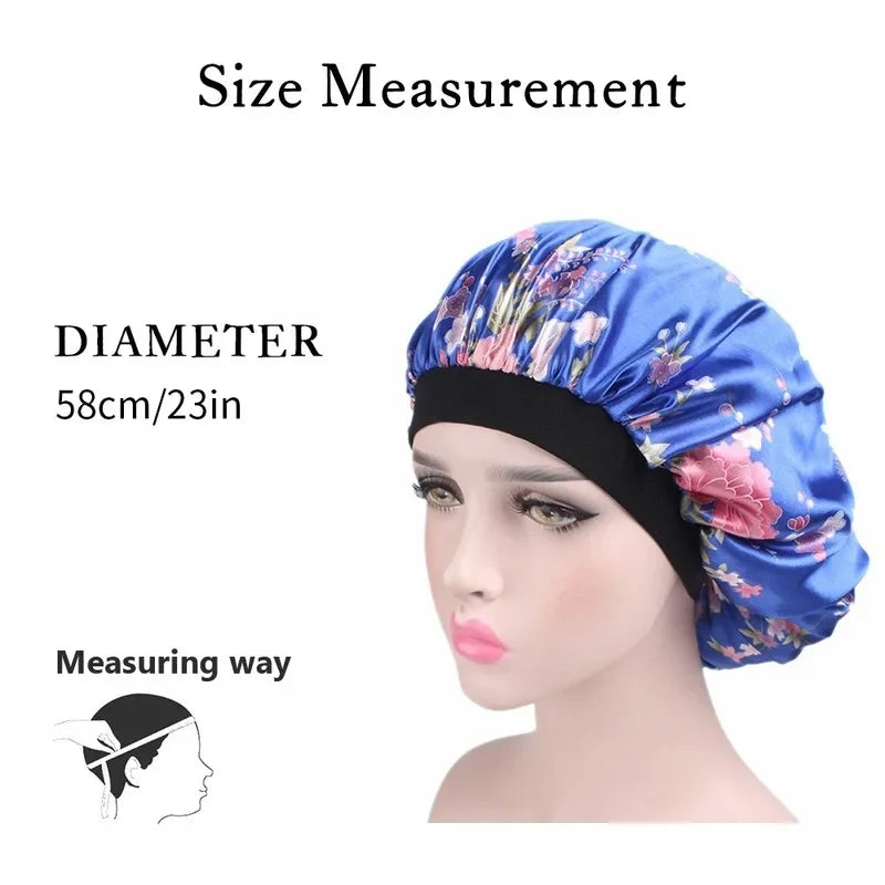 A model is shown wearing a blue floral satin sleep bonnet with a black elastic band, demonstrating the size measurement.