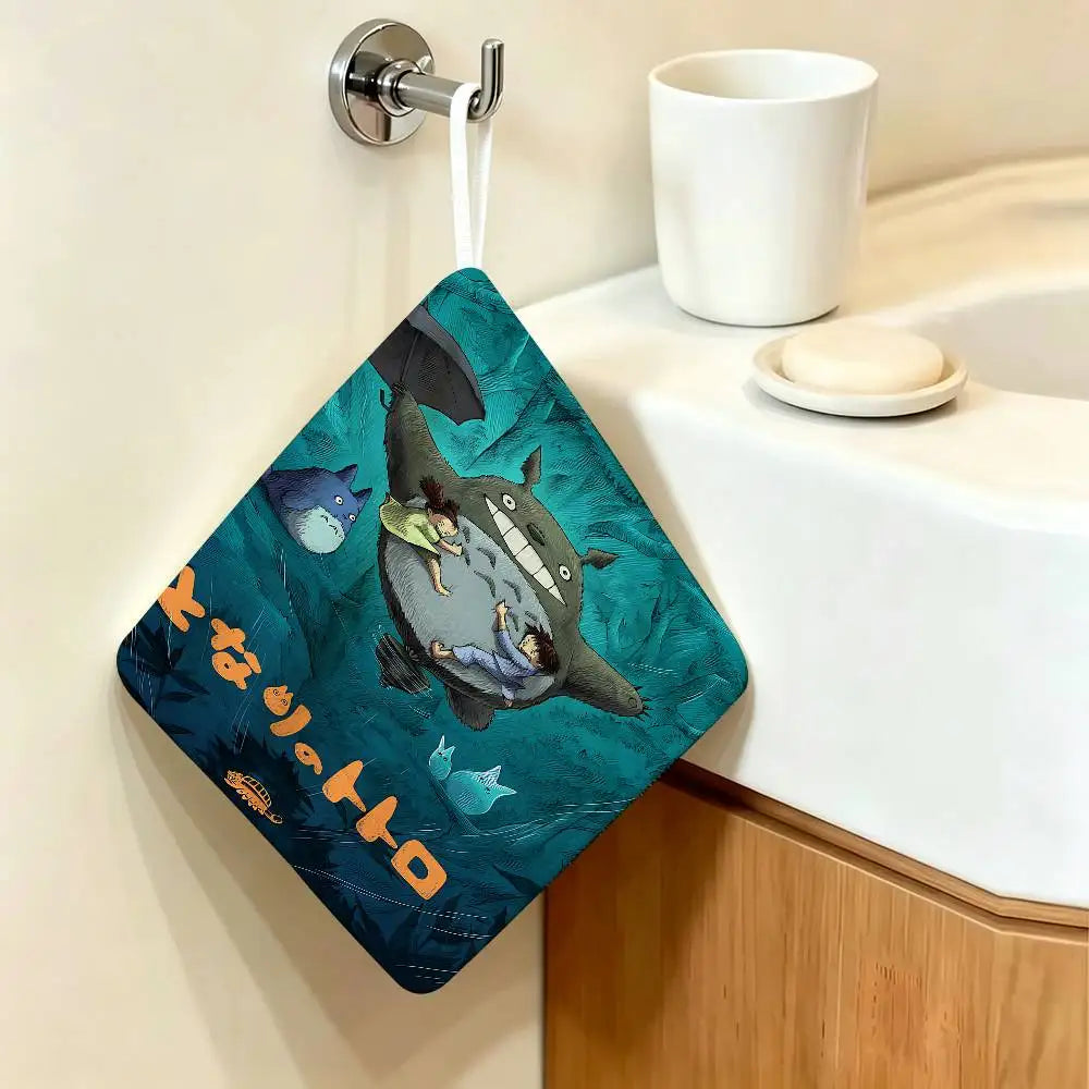 A dark teal cartoon-themed hanging hand wiping towel featuring Totoro characters mounted on a wall.