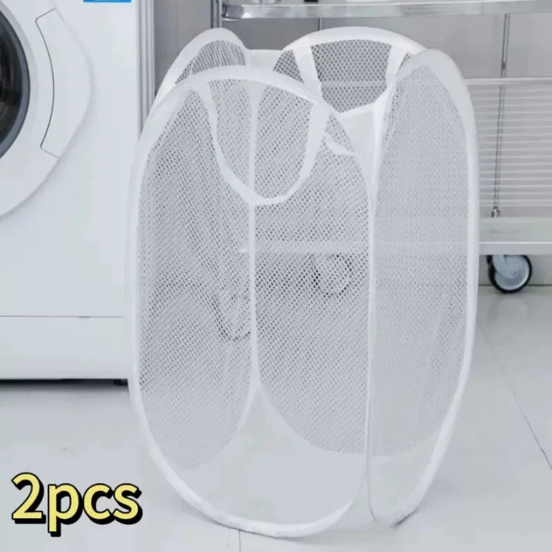 Two white foldable mesh laundry baskets displayed on a metal shelf.