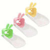 Three plastic faucet extenders shaped like rabbits in yellow, pink, and green.