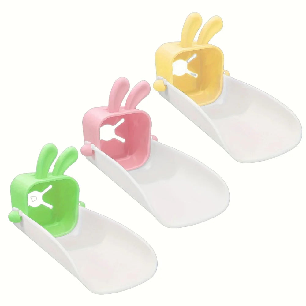 Three plastic faucet extenders shaped like rabbits in yellow, pink, and green.