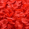 Primer plano de pétalos de rosa de seda artificial roja y vibrante usados para decoración.
