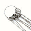 A set of stainless steel shower head cleaning brushes coiled together.