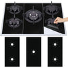 A black gas stove cooktop with four reusable anti-scratch protection pads placed on the surface.