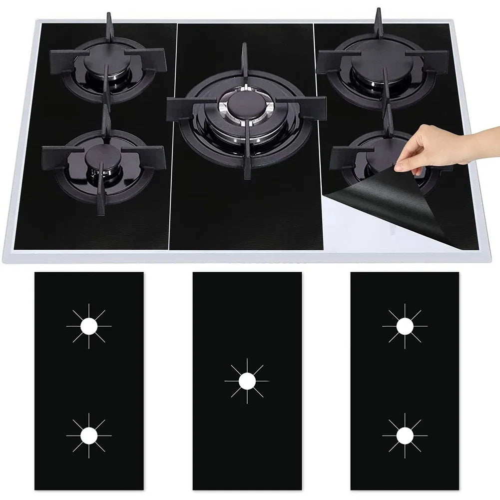 A black gas stove cooktop with four reusable anti-scratch protection pads placed on the surface.