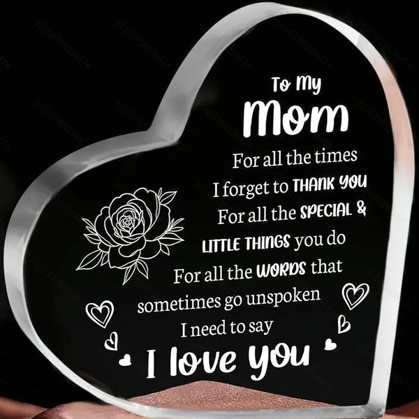 A clear acrylic heart-shaped keepsake engraved with the message I love you mom