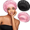 A woman models a pink satin hair bonnet and a black satin hair bonnet.