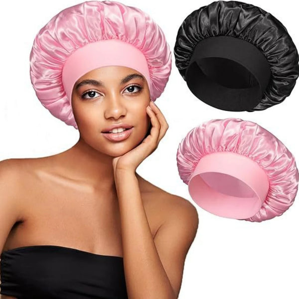 A woman models a pink satin hair bonnet and a black satin hair bonnet.
