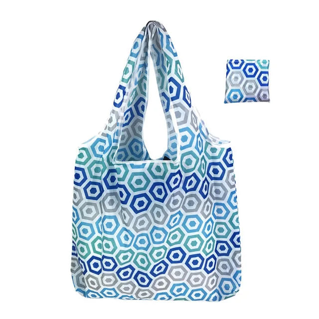 Wiederverwendbare Tasche mit geometrischem Muster in Blau- und Grautönen.