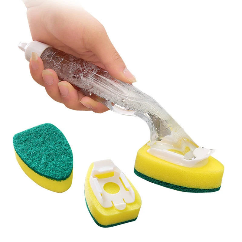 A hand is holding a clear dish wand cleaning brush and several yellow and green cleaning sponges.