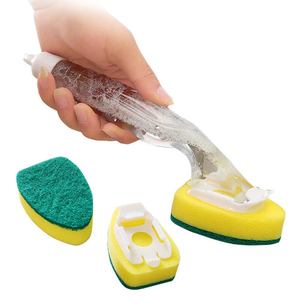 A hand is holding a clear dish wand cleaning brush and several yellow and green cleaning sponges.
