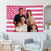 Eine vierköpfige Familie steht vor einer rosa-weißen amerikanisch-täglichen Flaggen-Wanddekoration.
