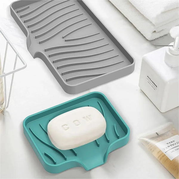 A silicone draining soap tray organizer with a white bar of soap is shown on a white surface.