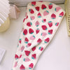 A pink and white strawberry print quick-drying hair towel headscarf laid flat.