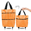 Orange polka dot foldable shopping bag being held by a hand