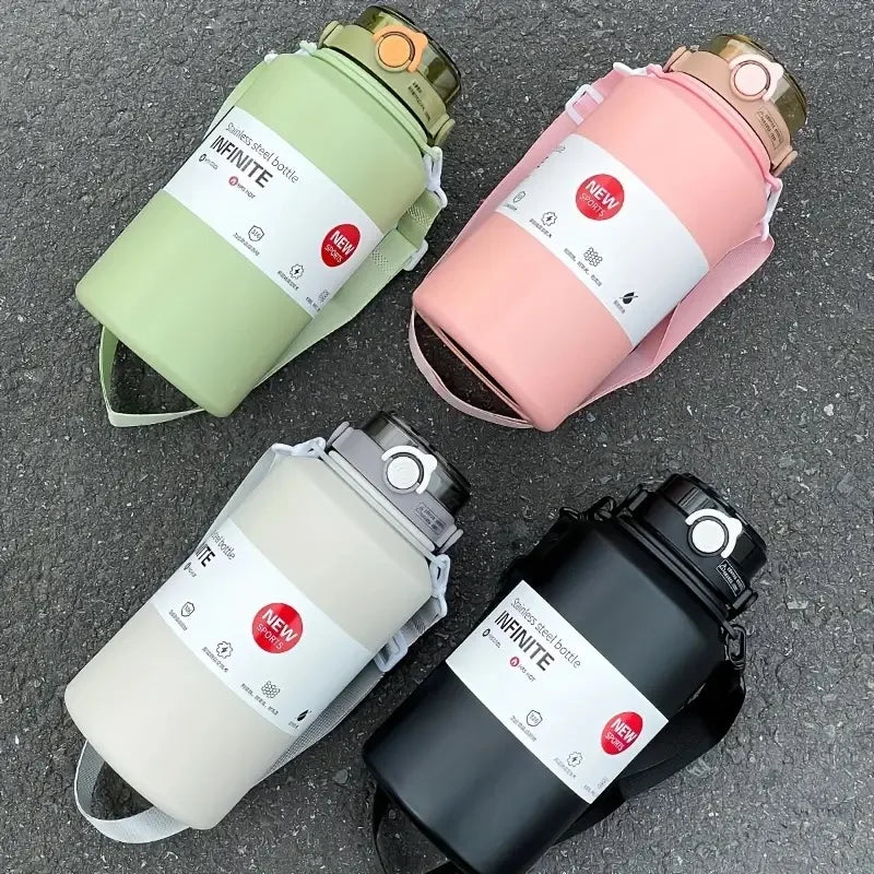 Three stainless steel insulated tumblers in green, pink, and black are displayed on a gray surface.