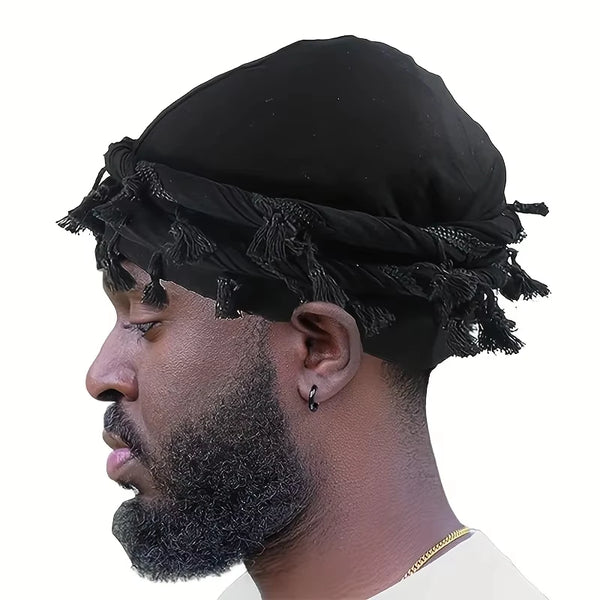 A close-up profile of a man wearing a black vintage twist head wrap durag with tassels.