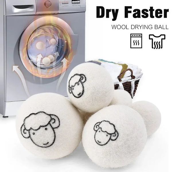 A set of white wool drying balls next to a laundry dryer machine.