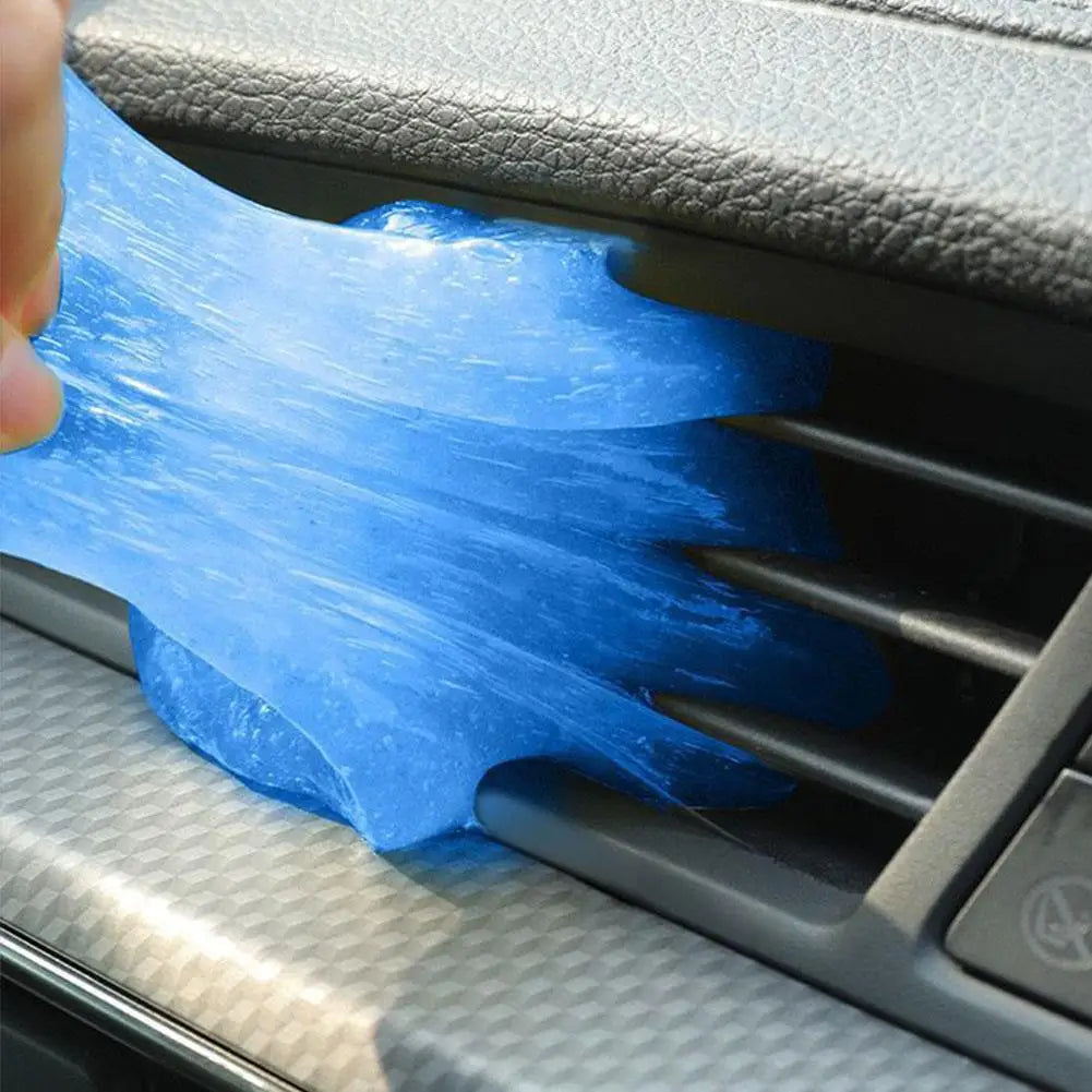 A hand is applying a blue, translucent gel to a grille or vent using a silicone applicator.