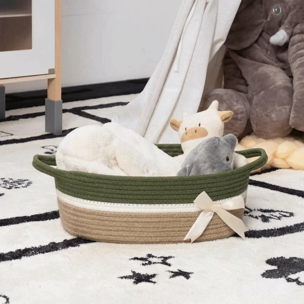 A woven cotton rope storage basket filled with soft, light-colored stuffed animals on a white rug.