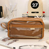 A brown transparent pencil pouch is shown on a white surface next to various writing tools and accessories.