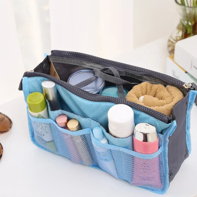 A blue foldable cosmetic organizer pouch with multiple compartments for storing makeup and toiletries.