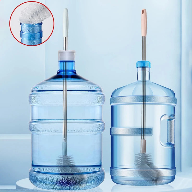 A clear plastic water dispenser bottle with a stainless steel cleaning brush and a glass water bottle.