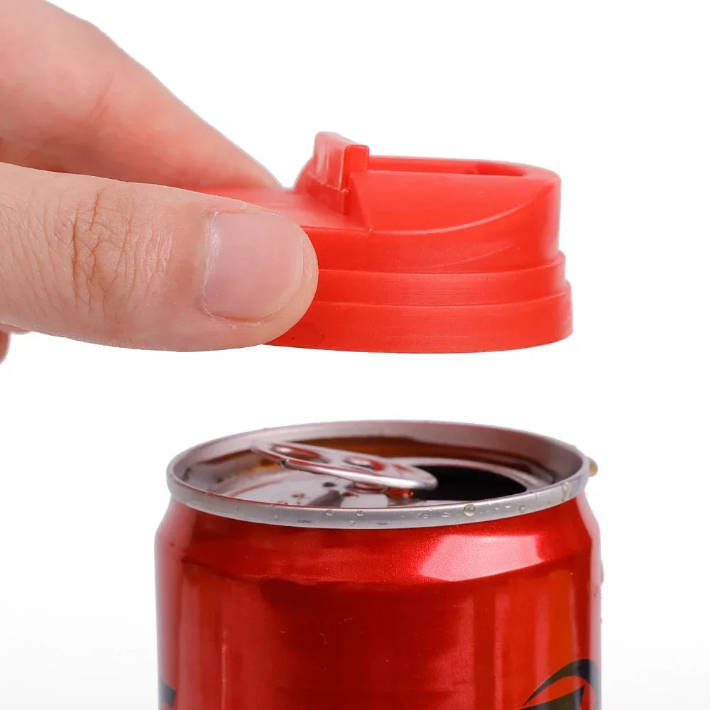 A hand is shown pressing a red plastic seal onto the opening of a red beverage can.