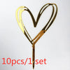 A set of ten gold acrylic heart-shaped birthday cake toppers with a stick.