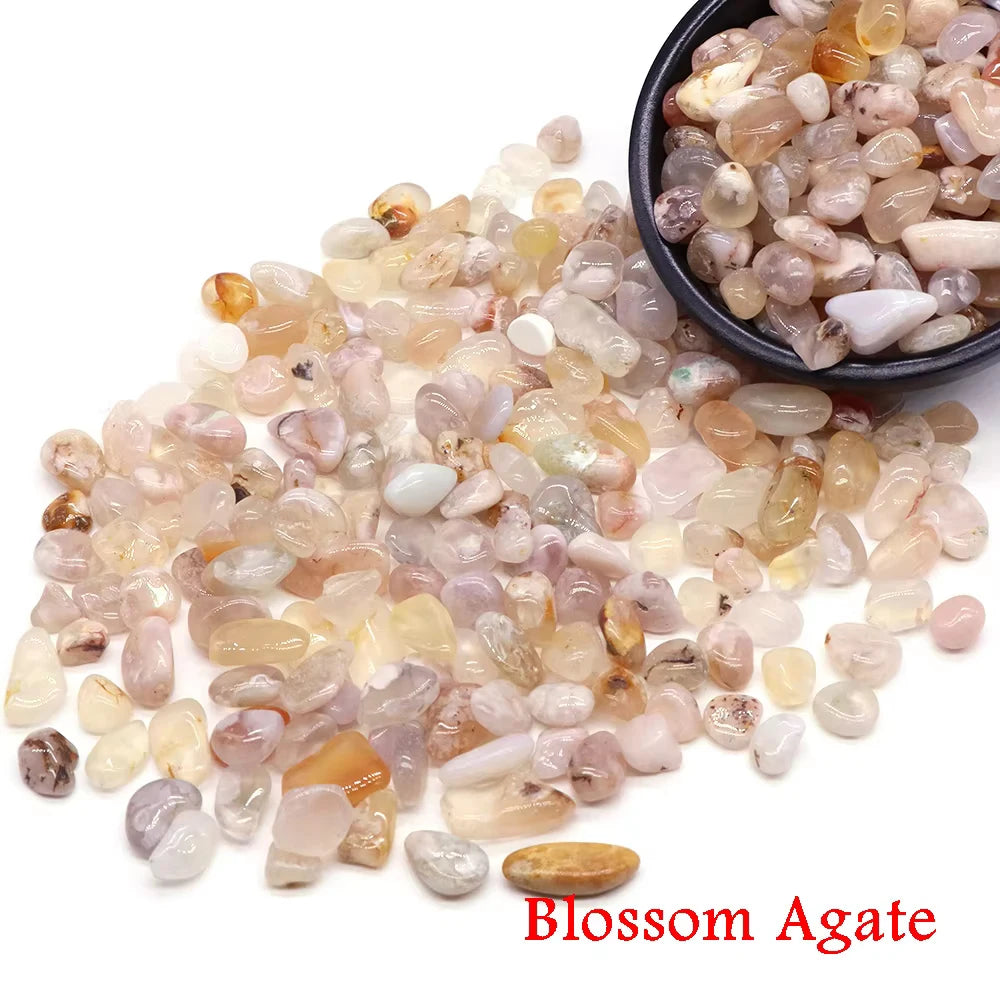 Pila de cristales de ágata Blossom en varios colores translúcidos y lechosos, algunos contenidos en un cuenco negro.