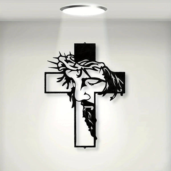 A black metal cross wall art featuring a carved face and beard design, illuminated by a spotlight.