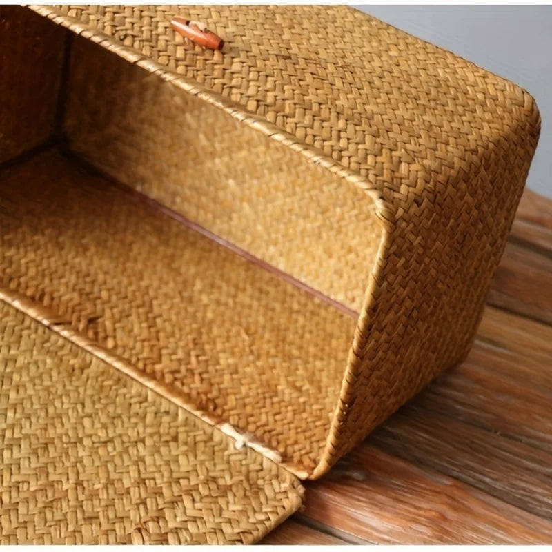 A close-up view of a handwoven rattan storage basket with a lid resting on a wooden surface.