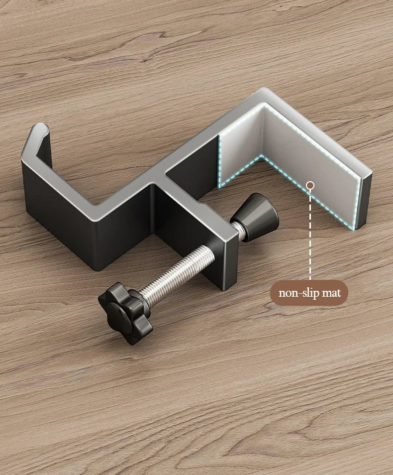 A silver aluminum desk hanging hook with a threaded attachment is shown on a wooden surface.