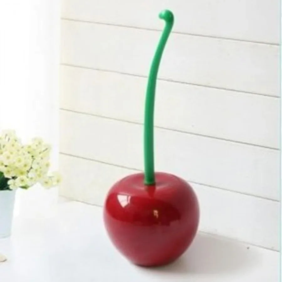 A bright red decorative cherry-shaped toilet brush with a green handle.
