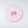 A pink reusable fruit shower cap with a stylized cursive word like on it.