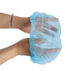 A hand wearing a light blue disposable microblading hair net cap for permanent makeup.