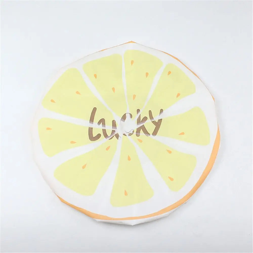 A reusable fruit shower cap with a yellow lemon slice design and the word lucky printed on it.