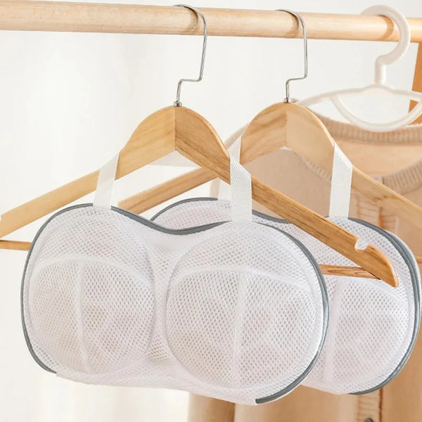 White mesh laundry bag designed for storing bras and undergarments hanging on a wooden hanger
