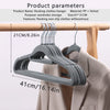A set of gray plastic flocking clothes hangers displayed on a wooden rack.