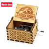 An antique wooden music box with a Jurassic Park theme featuring an engraved lid and decorative wood paneling.