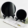 A black obsidian scrying mirror decor is shown resting on a piece of paper.