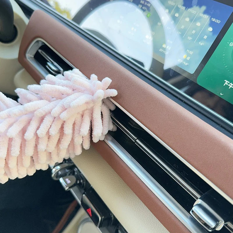 A pink extendable microfiber duster brush is shown inserted into a cleaning tool or device.
